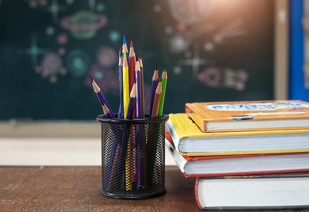 School books and pencils on desk
