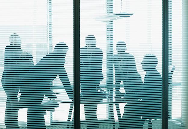 ilouhette of business people in office behind courins
