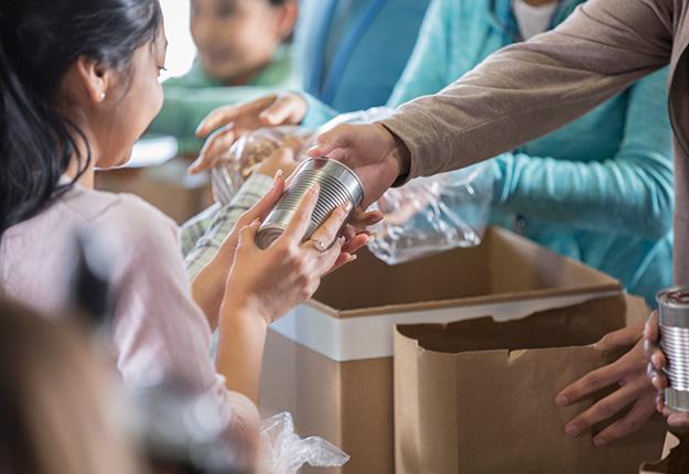 Woman hands out food to a person in need