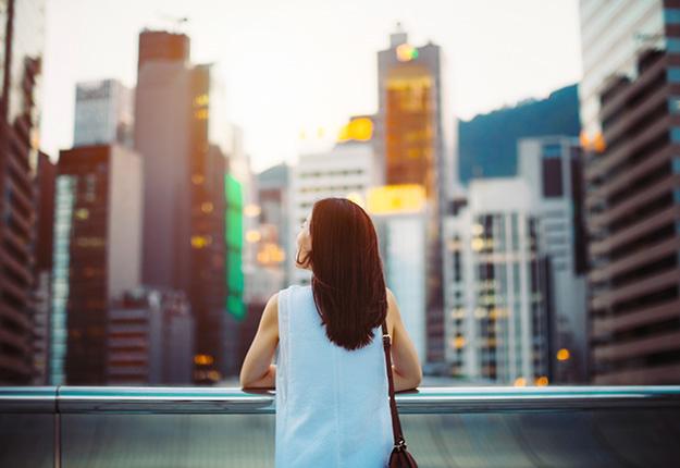 Woman looking up to buildings