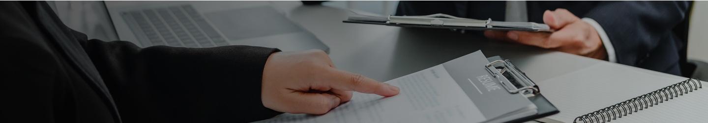 Two businessmen analyze a document in a clipboard.