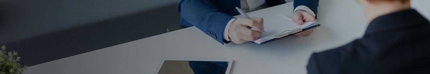 Businessman interviewing a lady while holding a clipboard.