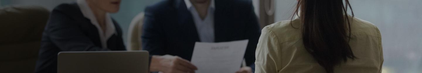 Hiring managers looking a candidate's resume at a table.