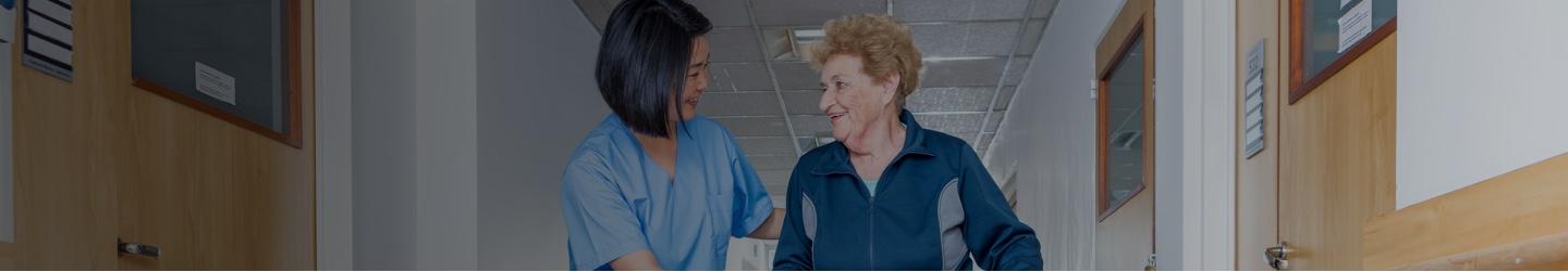 Nurse helping an old lady to walk with her walker