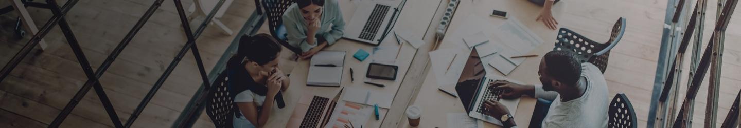 Overhead view of an office environment, professionals working at their desks and have conversations