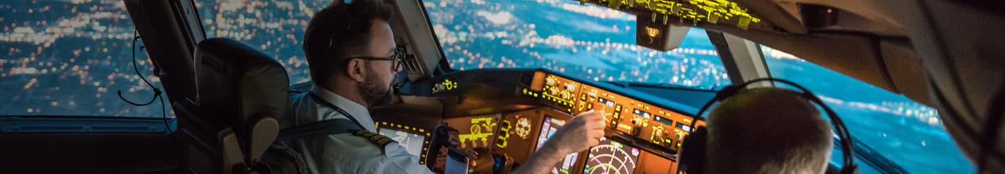 Pilot in a cocpit flying a commercial airplane