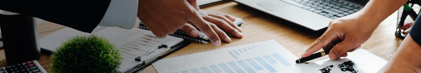 Businesspeople revising charts on a paper