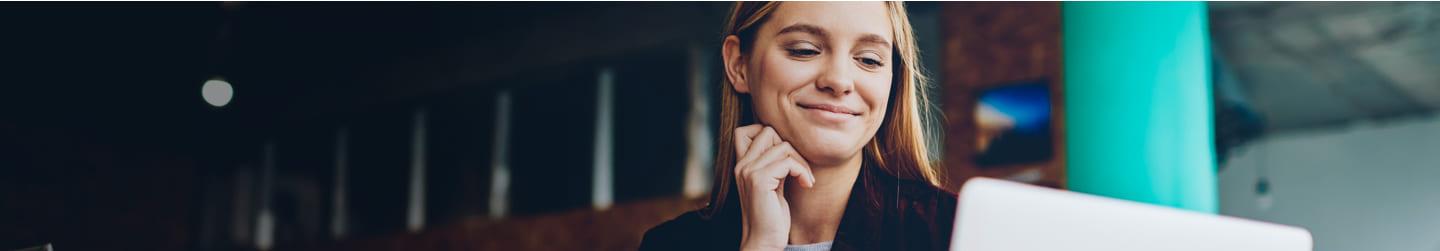 Woman looking happily at her computer screen