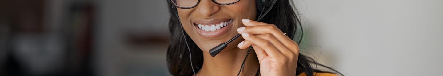 Woman talking through a headset while smiling 