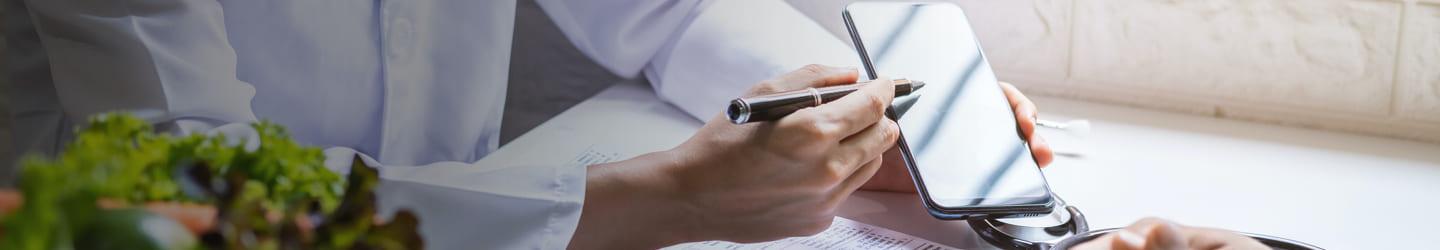 Nutritionist showing a diet plan on a cellphone to a patient