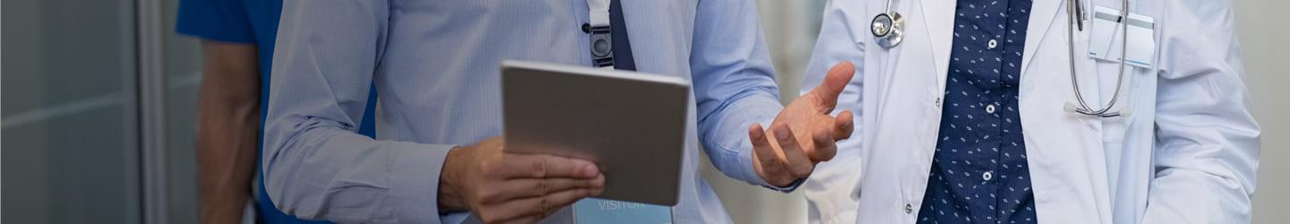 Medical doctors discussing while walking in a hospital hallway