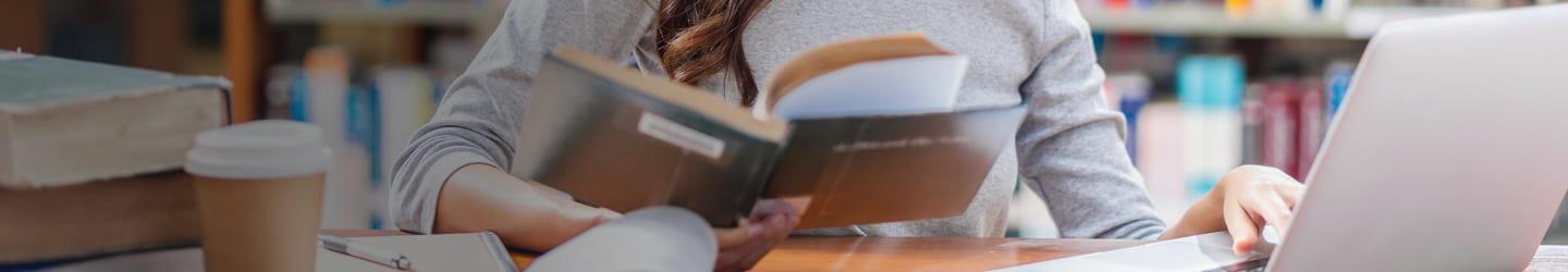 Young woman reading a book at the library