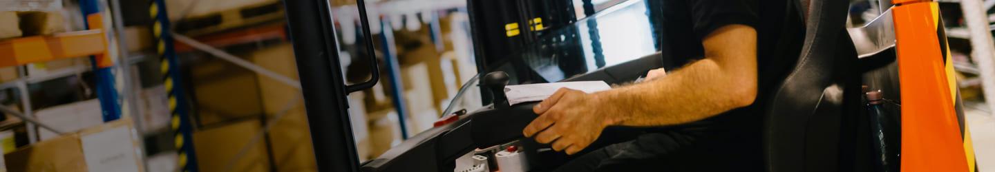 Man operating a forklift ain a warehouse