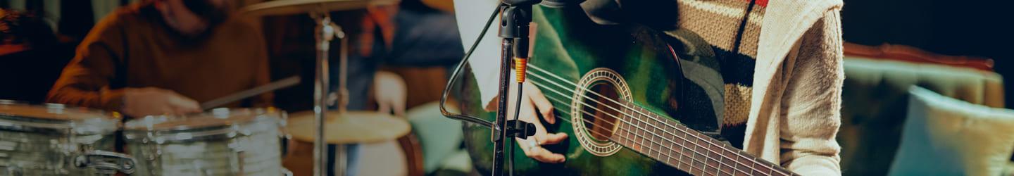 Band playing music while woman sings and plays guitar