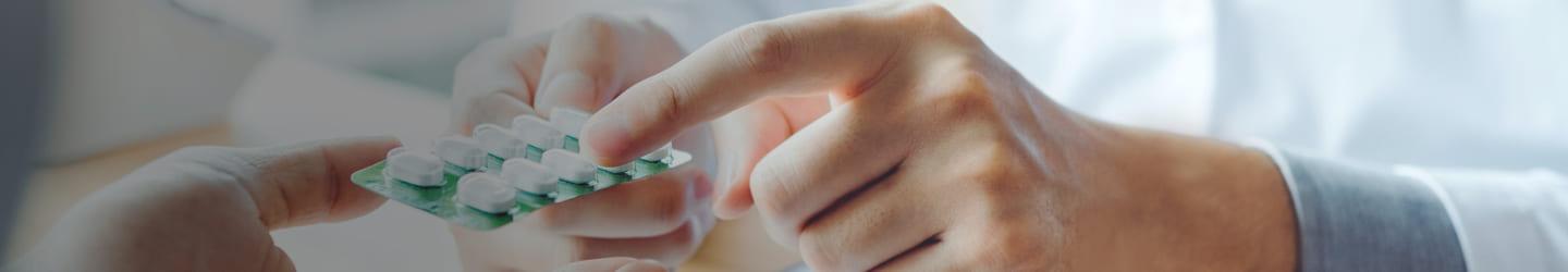 Pharmacist handing pills to a patient