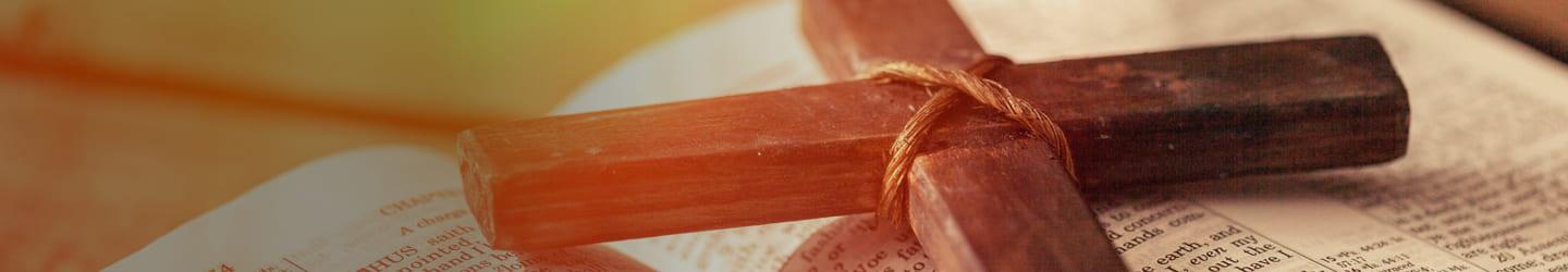 Wooden cross on top of an open Bible