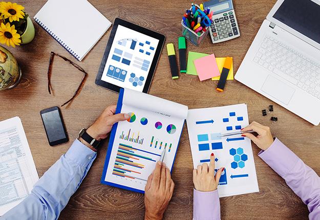 Top view of two business people studying budget reports