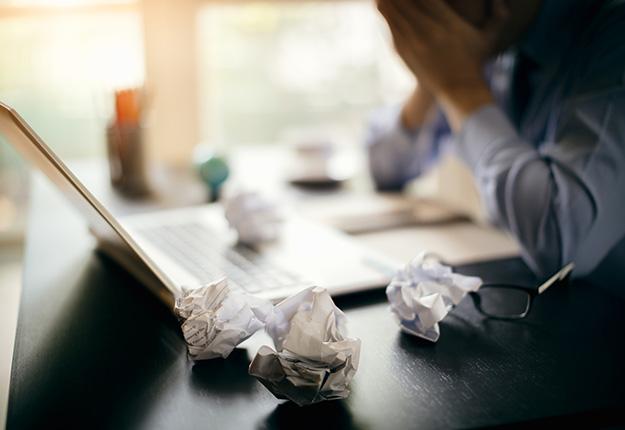 Businessman frustrated in desk with laptop