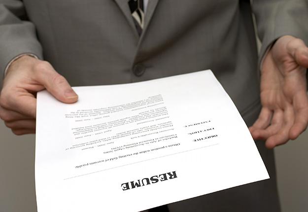 Man in a suit holding a resume