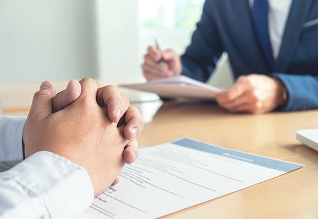 Man with hands crossed and resume at an interview