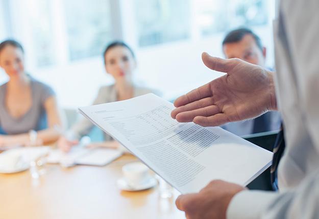 Businessman talking to a panel in a meeting