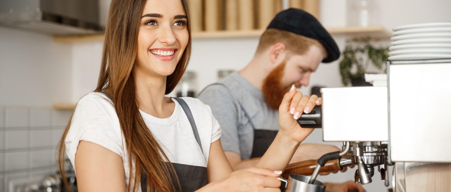 Barista couple working with a coffee maker