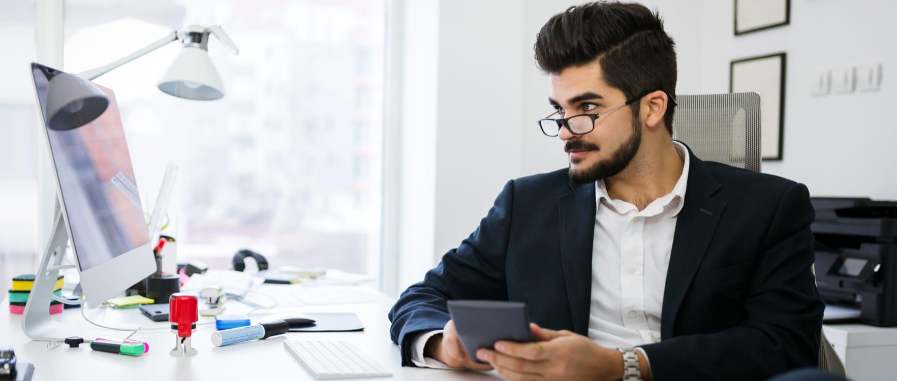 Businessman at his desk working with a calculator