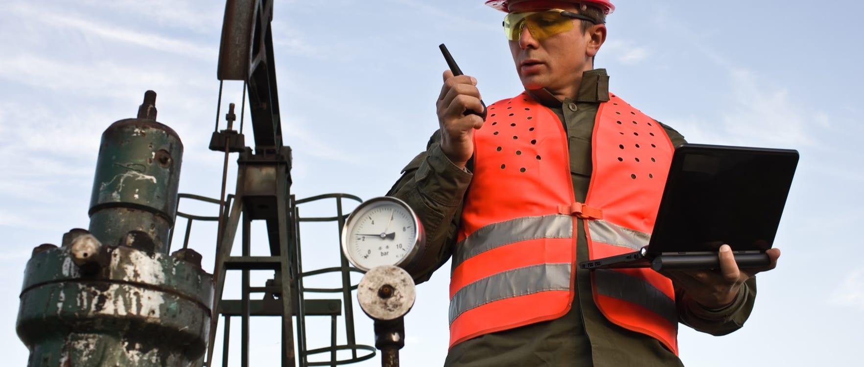 Man with safety gear inspecting a valve