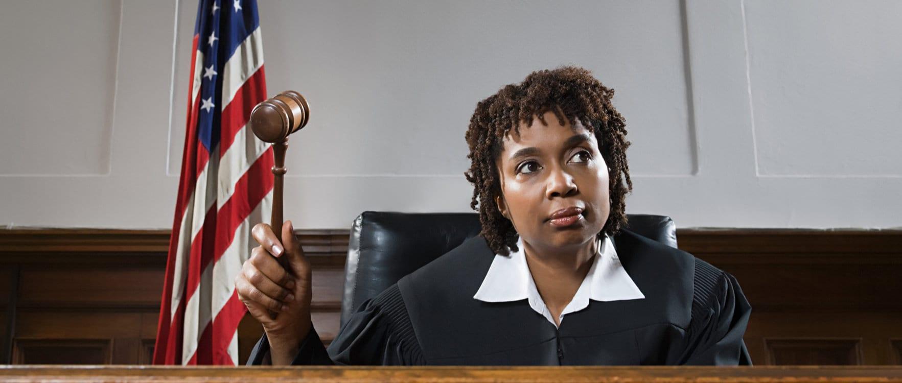 A female judge sitting at her bench holding a gavel