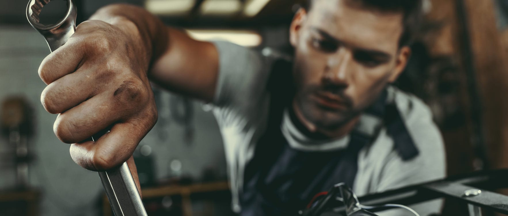Man working with a wrench at a workshop