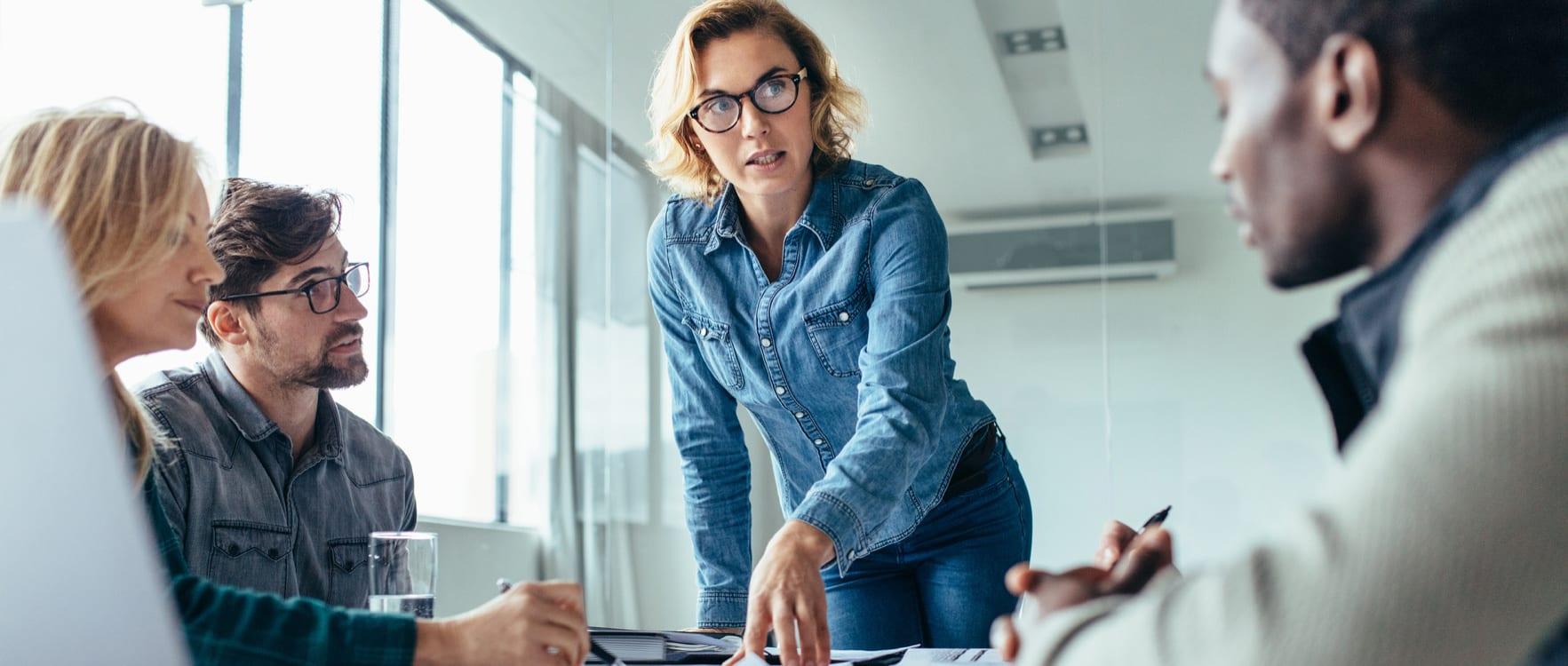 Lady talking to her team in a conference room