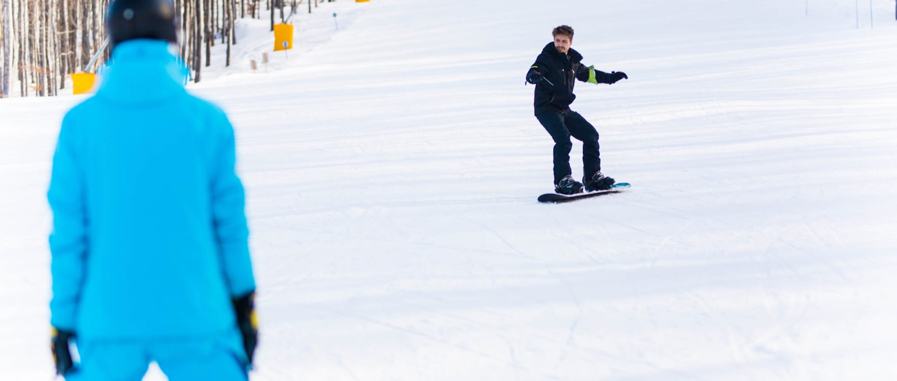 Man watching another man snowboarding