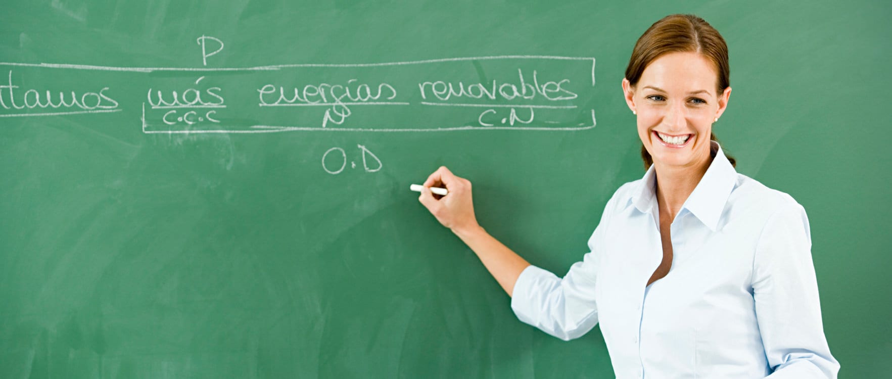 Woman writing Spanish words on a chalk board