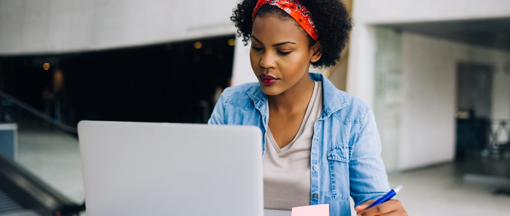 Woman using a laptop and taking notes