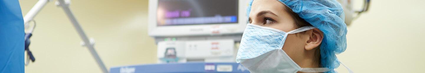 Medical Professional wearing a mask and monitoring on a screen