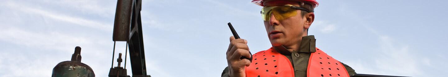 Drilling engineer in red hat monitors drilling data on a device