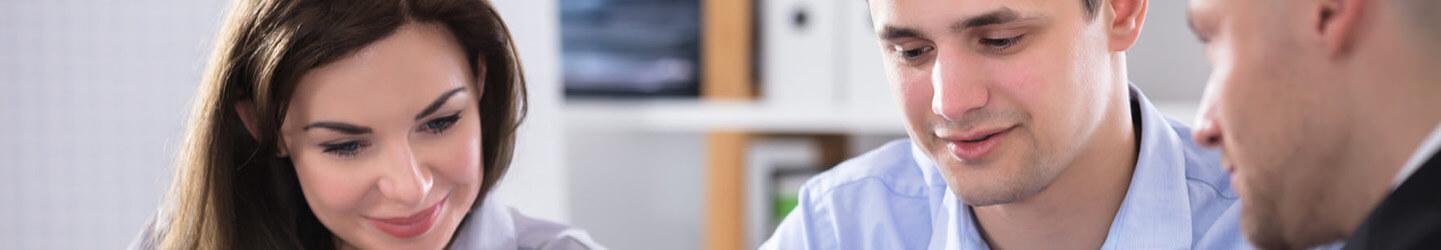 young female business professional discussing a project with her male colleagues in an office