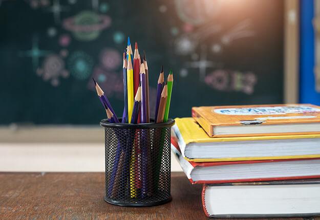 School books and pencils on desk