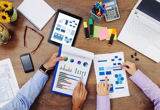 Top view of two business people studying budget reports