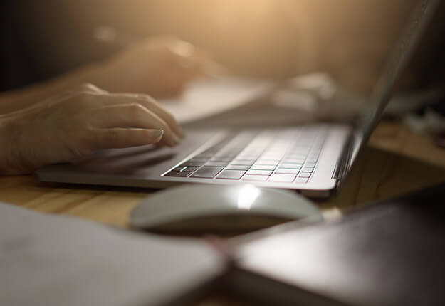 Female in a desk with laptop and books