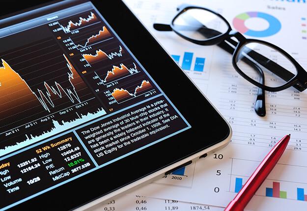 Financial analysis graphs in tablet and paper