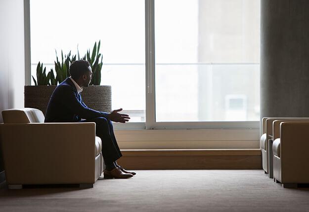 Businessman sitting down in lobby thinking