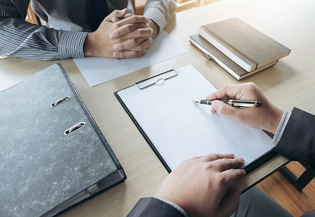 Businessman intervieweing a candidate resume on desk