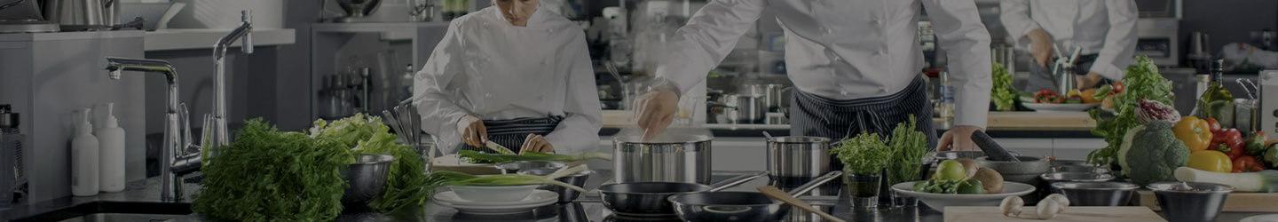 Group of prefessional chefs cooking at a kitchen