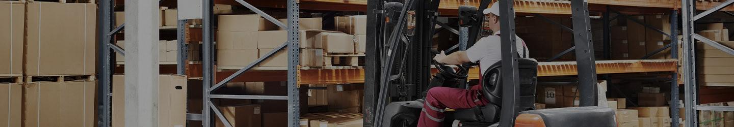 Man operating a forklift at a storage room