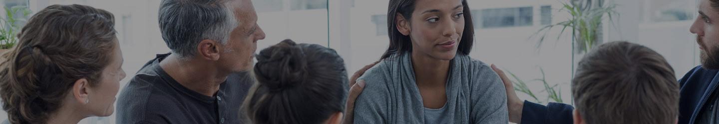 Therapy group giving support to a woman