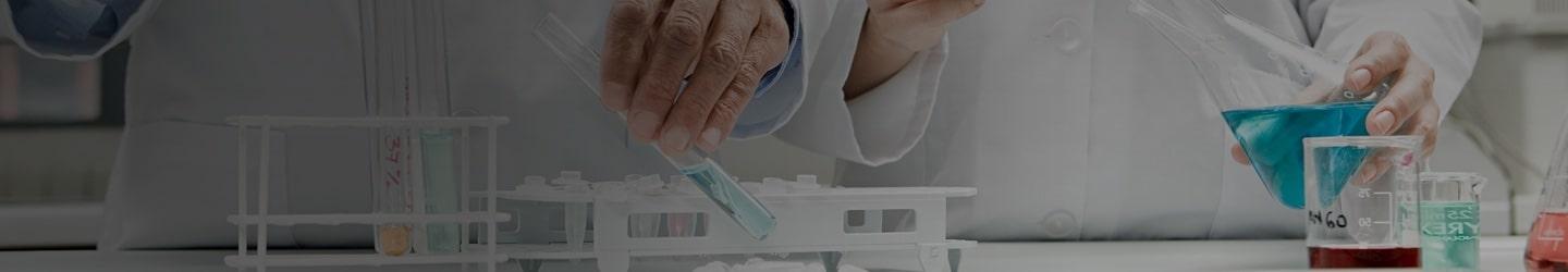 biotech scientist holding a vial of blue liquid in a laboratory